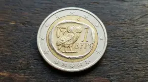 Moneta da 1 euro greca con gufo inciso su sfondo in legno