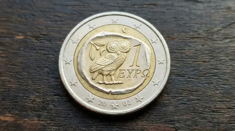 Moneta da 1 euro greca con gufo inciso su sfondo in legno
